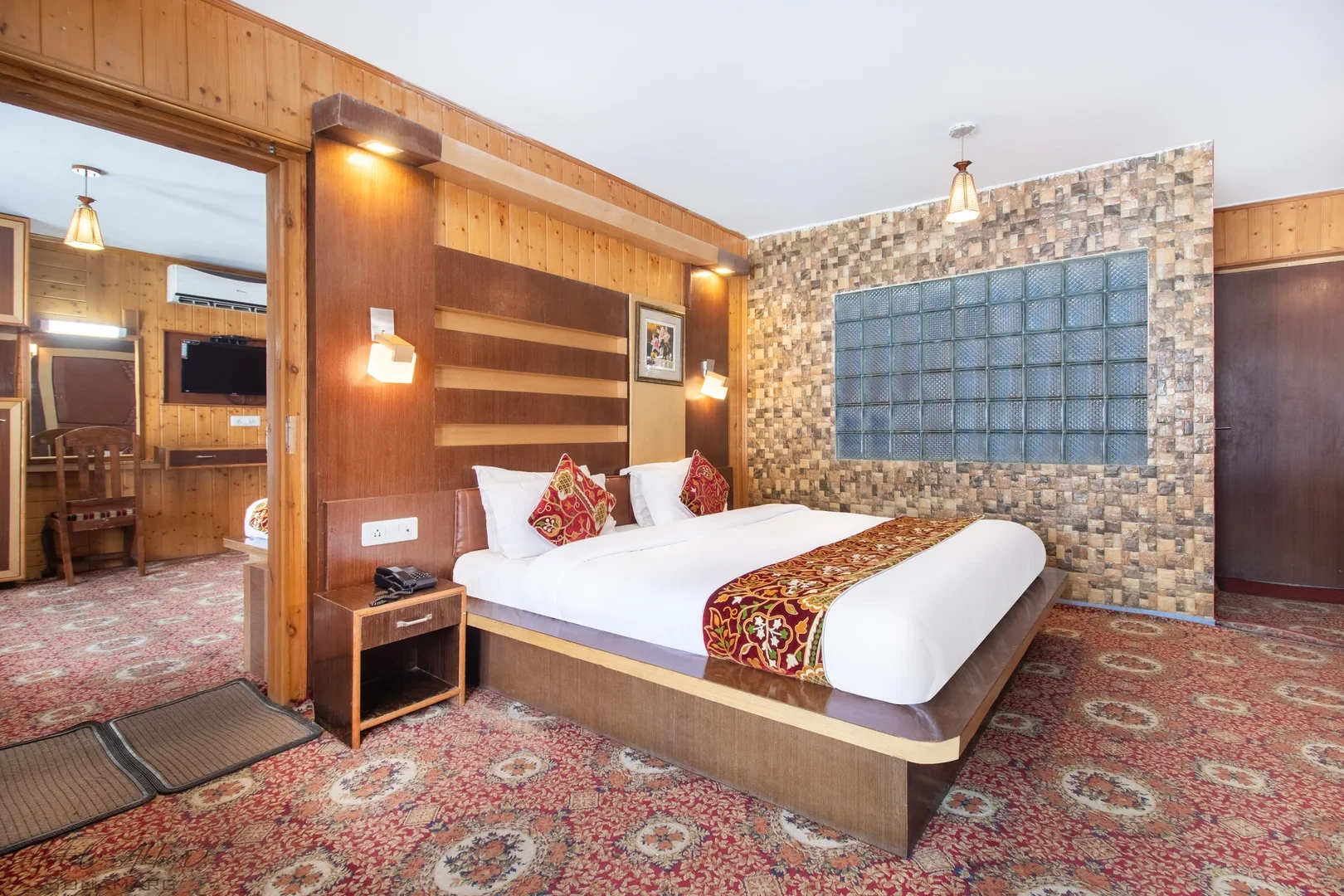 Spacious luxury bedroom featuring stone headboard accents.